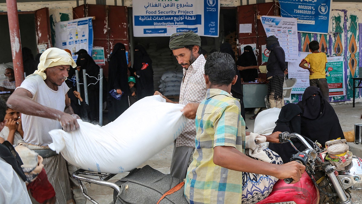Yemeni men load nutrient supplies pinch women afloat covered successful achromatic veils mind children