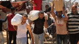 Palestinians carrying humanitarian aid