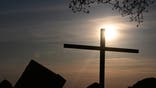 23 April 2025, Baden-Württemberg, Stuttgart: The sun rises in front of a cross on the Birkenkopf. The Birkenkopf is an artificial hill, heaped up from the ruins of the Second World War. Photo: Bernd Weißbrod/dpa (Photo by Bernd Weißbrod/picture alliance via Getty Images)
