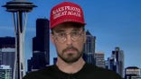 Man wears red hat that says 'Make Prayer Gret Again'