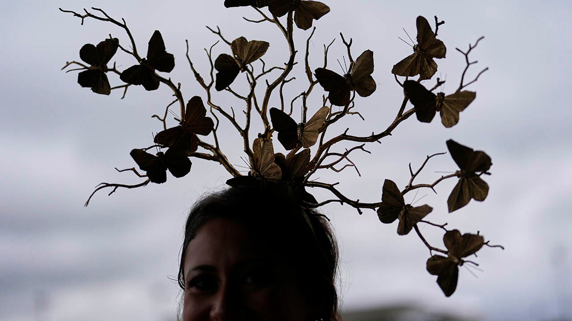A woman with a butterfly hate at Churchill Downs