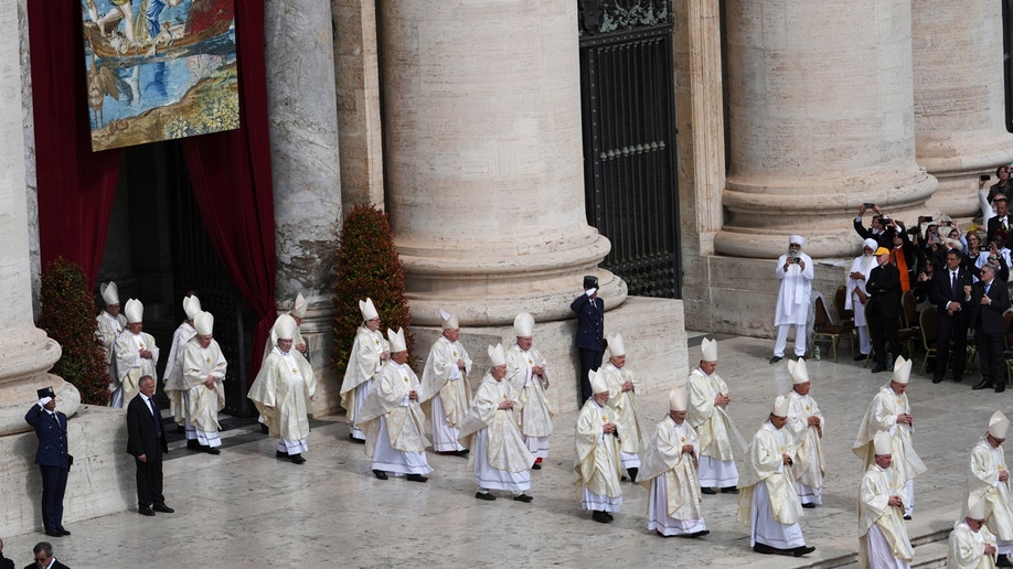 Cardinals dressed in white proceed to Pope Leo XIV's inaugural mass.