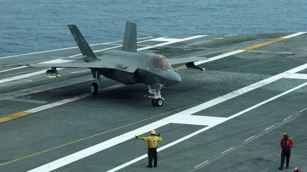 A flight deck crew signal to F-35 jet on USS George Washington during Freedom Edge trilateral exercise among United States, Japan and South Korea in the East China Sea, south of the Korean peninsula and west of Japan's main islands November 14, 2024.