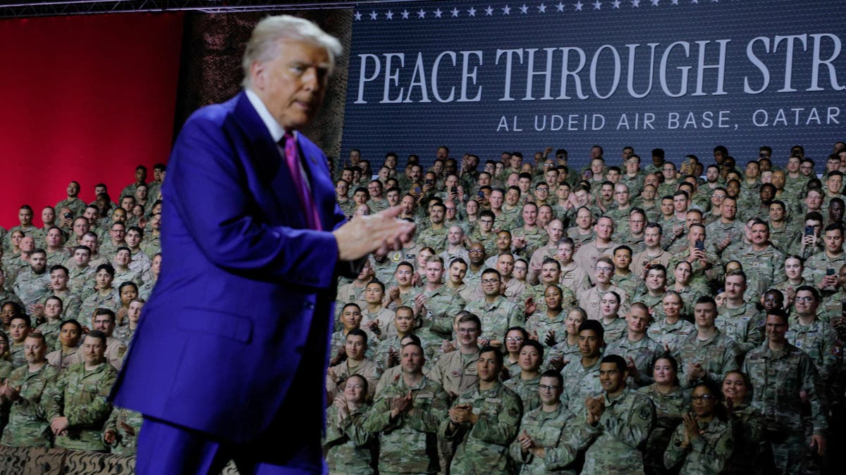 U.S. troops react as President Donald Trump walks to deliver remarks, near a banner reading, "Peace Through Strength", during a visit to Al Udeid Air Base in Doha, Qatar, May 15, 2025.