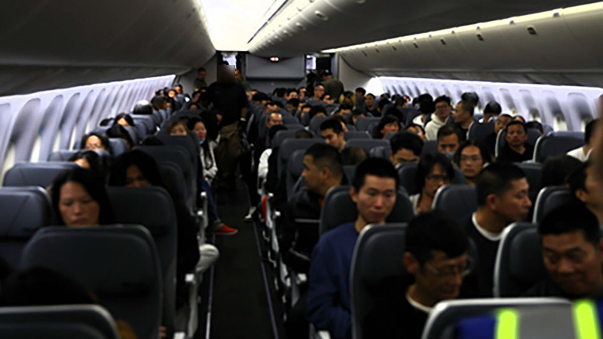 Internal appearance to a plane booth full of seated deportees waiting for departure