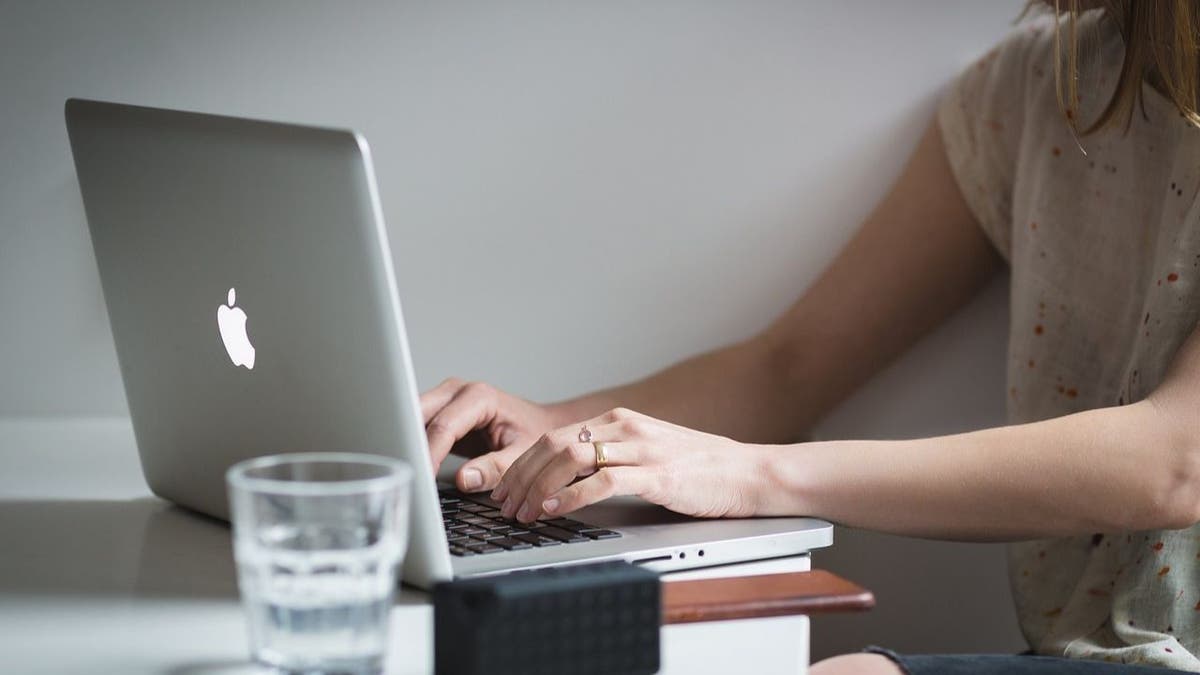 A woman typing on her laptop.