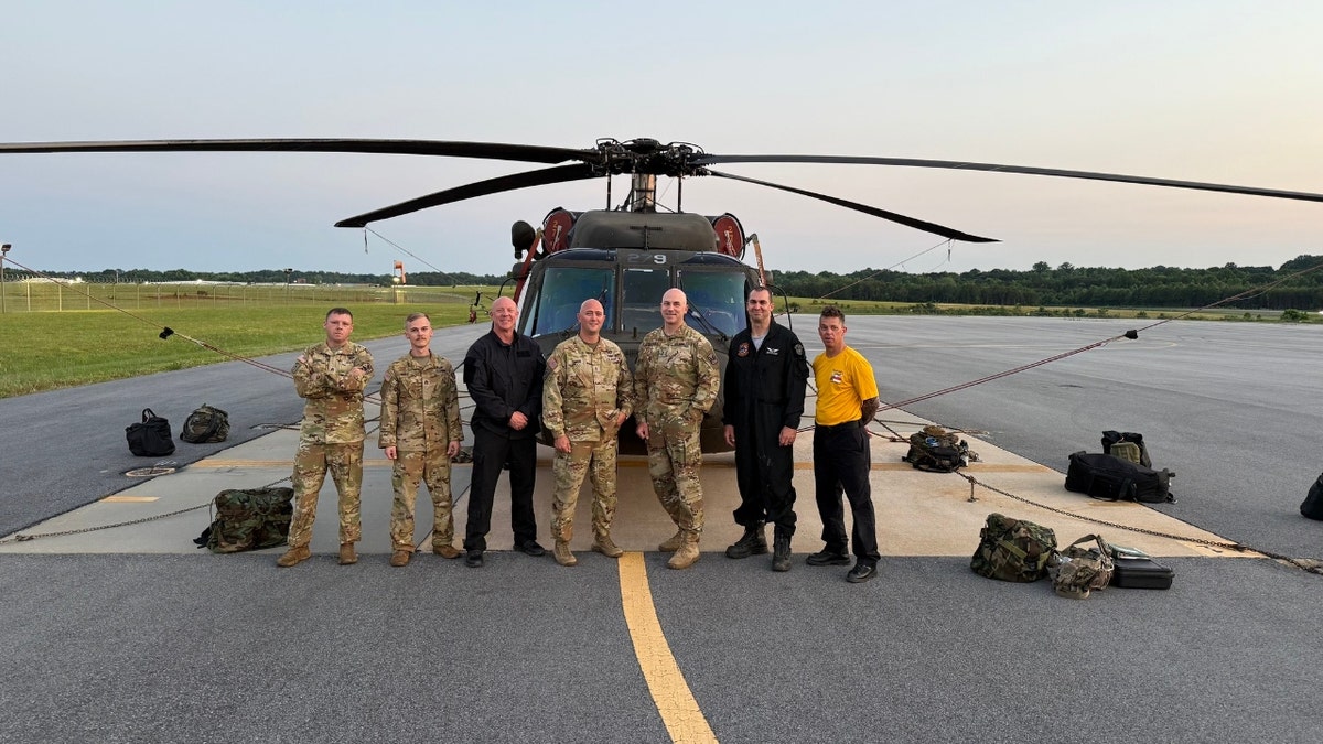 North Carolina emergency and military personnel pose outside a Black Hawk helicopter