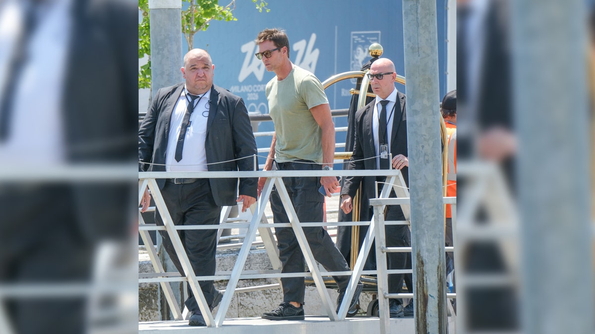 Tom Brady sports green shirt and grey slacks on dock