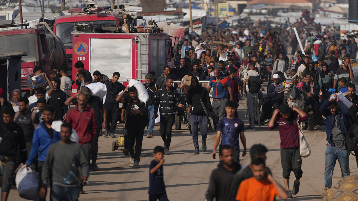 Palestinians carry boxes and bags containing food and humanitarian aid packages