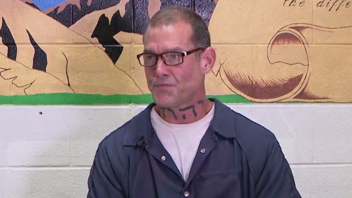 Adam sheafe in blue jail jumpsuit and glassess
