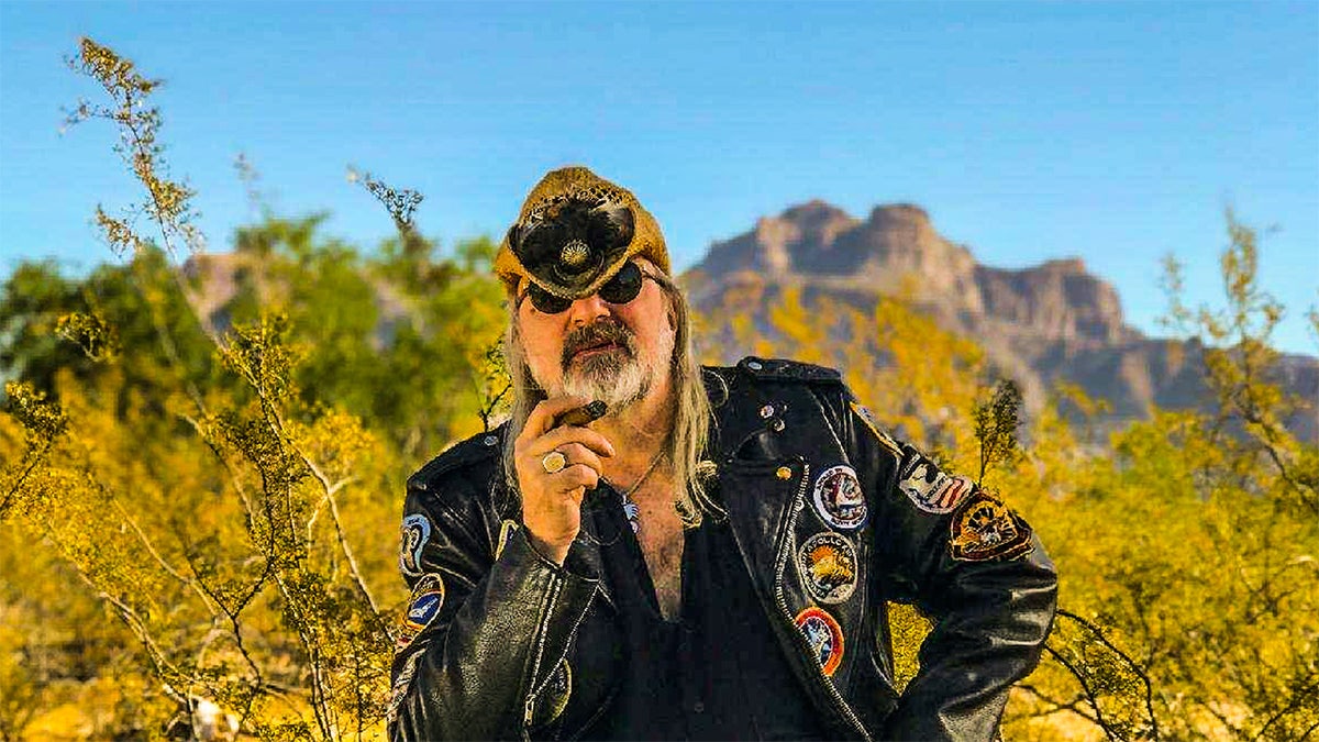 Alan Niven smoking a cigar pinch a cowboy chapeau retired successful nan field.