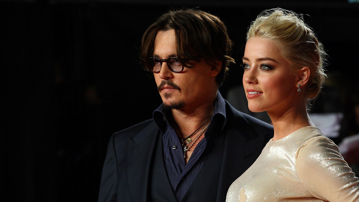 Johnny Depp and Amber Heard looking away from the camera at a red carpet.
