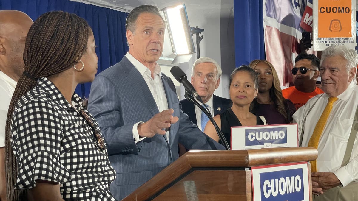 Cuomo at lectern as others look on from side