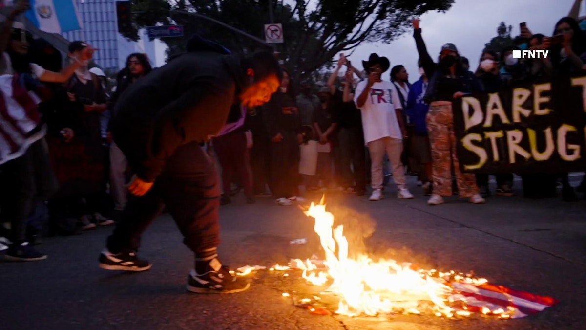 anti-ice-protest-la-man-spits-on-american-flag Os manifestantes de Los Angeles queimam bandeiras americanas durante demonstrações anti-Trump