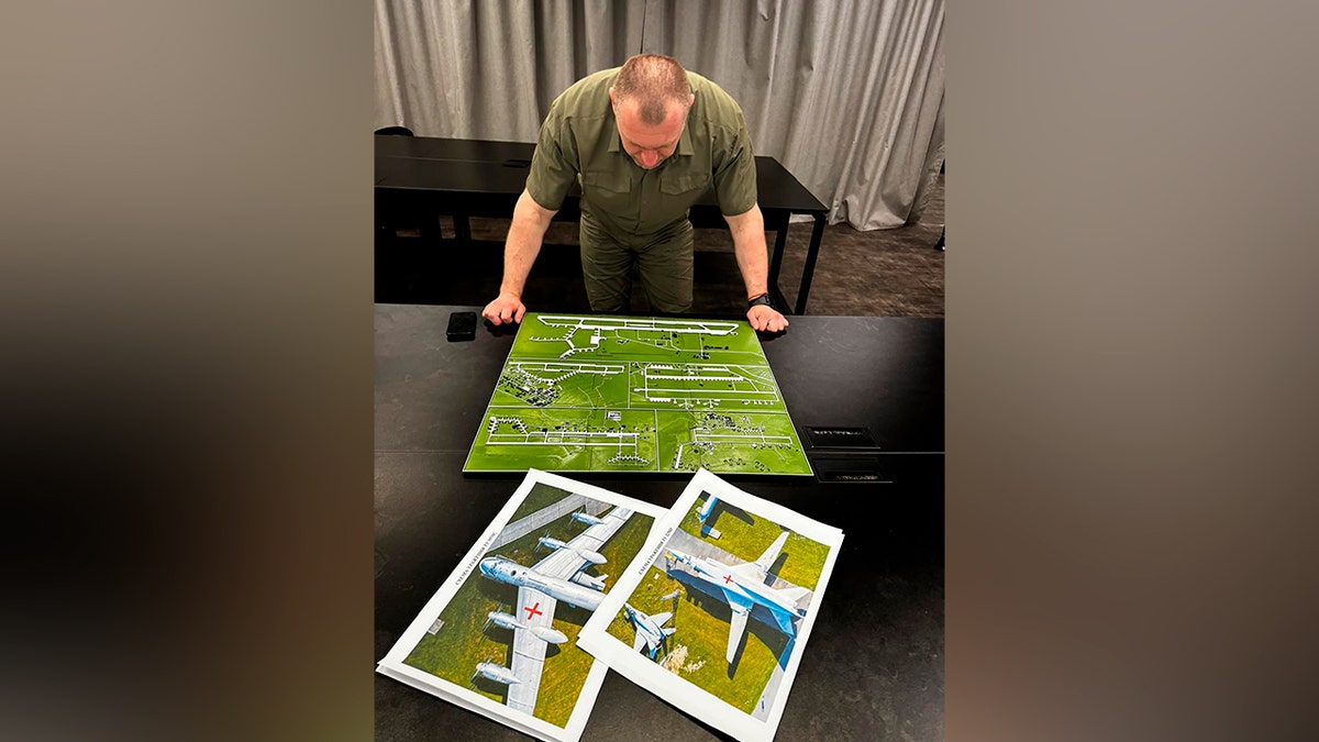 Ukrainian Security Service head Vasyl Malyuk studies a photo of a map of Russia's strategic aviation location .