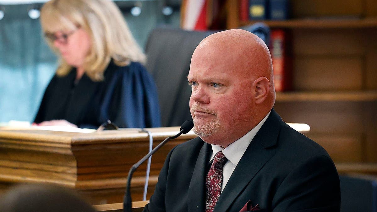 Canton DPW snowplow driver Brian Loughran on the witness stand, with judge Beverly Cannone in the background