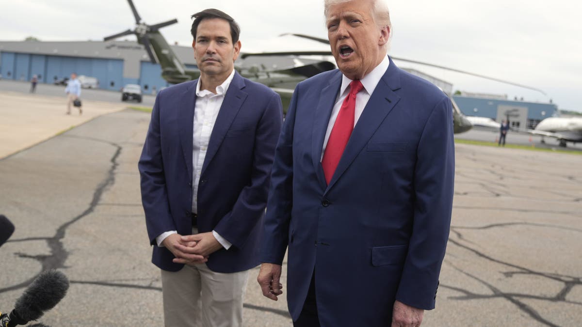 President Donald Trump, right, speaks with reporters as Secretary of State Marco Rubio listens upon arriving at Morristown Municipal Airport in Morristown, New Jersey, en route to Camp David, Maryland, on Sunday, June 8, 2025.