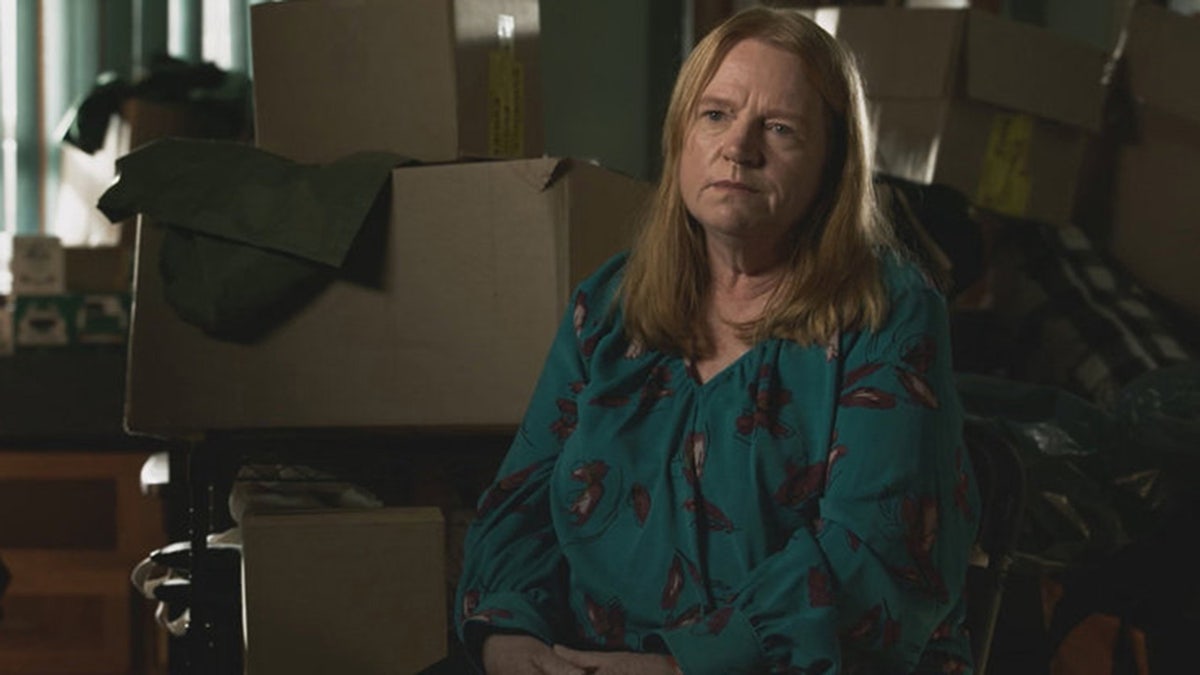 Asa Ellerup sitting in front of boxes wearing a blue blouse.