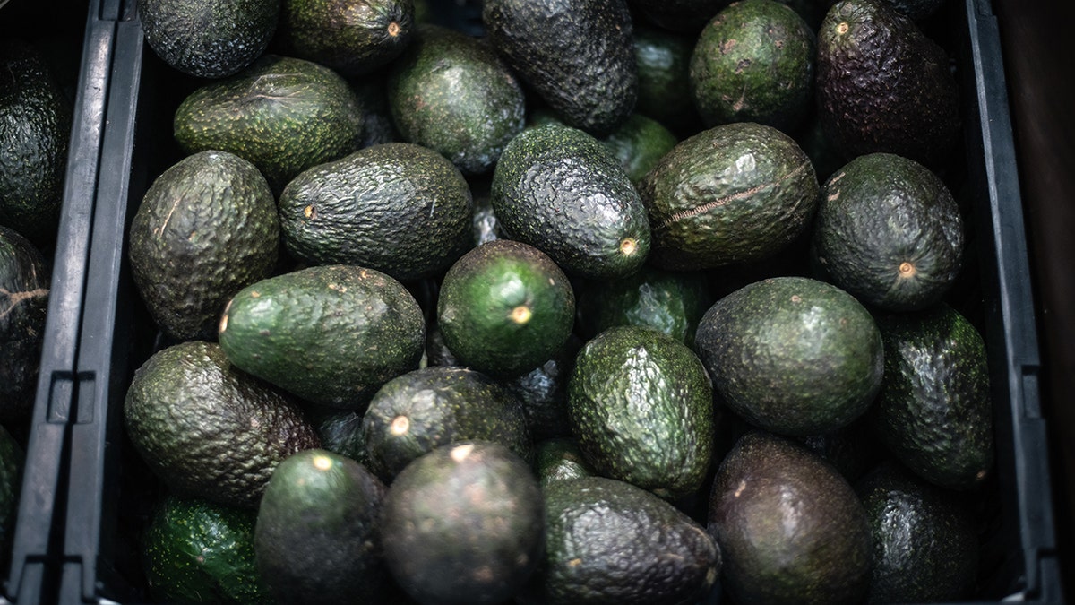 Avocados are shown in a black bin at Walmart.