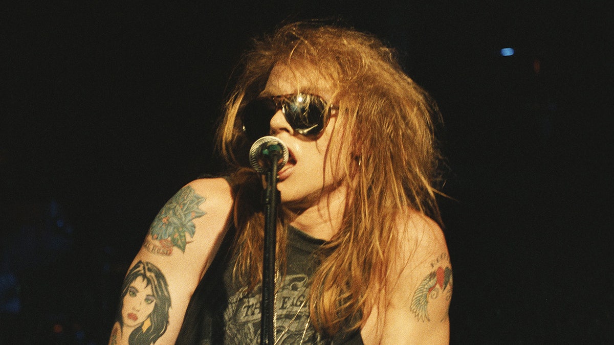 A close-up of Axl Rose singing connected stage.