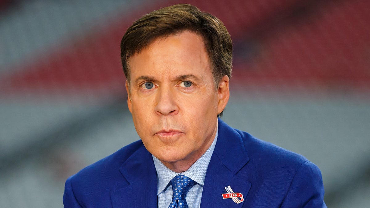 Bob Costas looks on