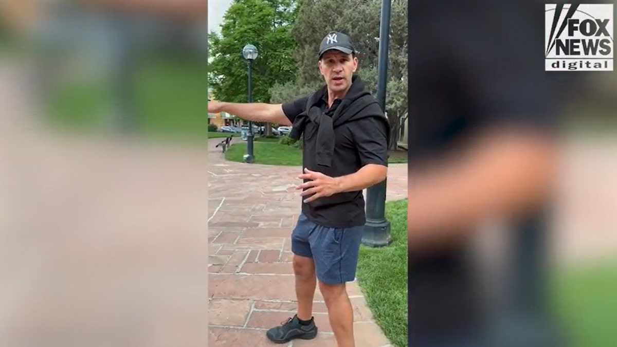 Alex Osante, wearing a black shirt and blue shorts, describes the scene of Sundays firebombing in Boulder.