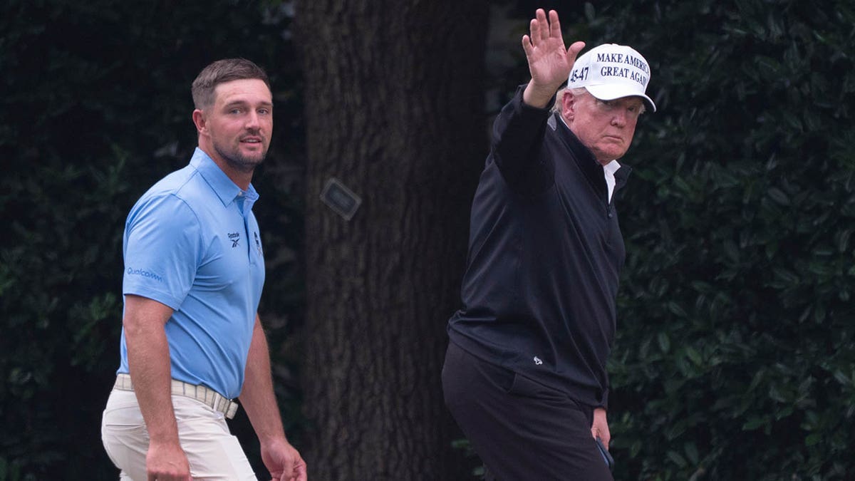 Donald Trump waves to reporters