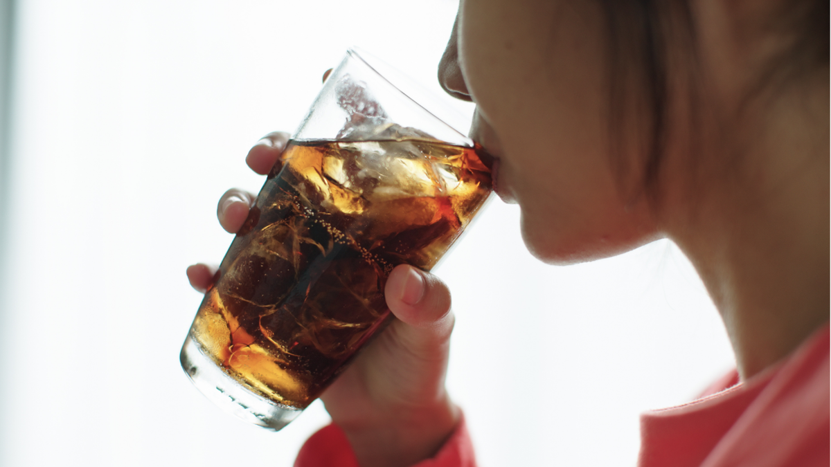 Woman drinking soda out of glass