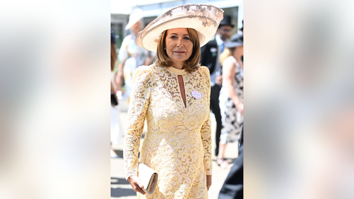 Carole Middleton wearing an ivory lace formal and matching hat.