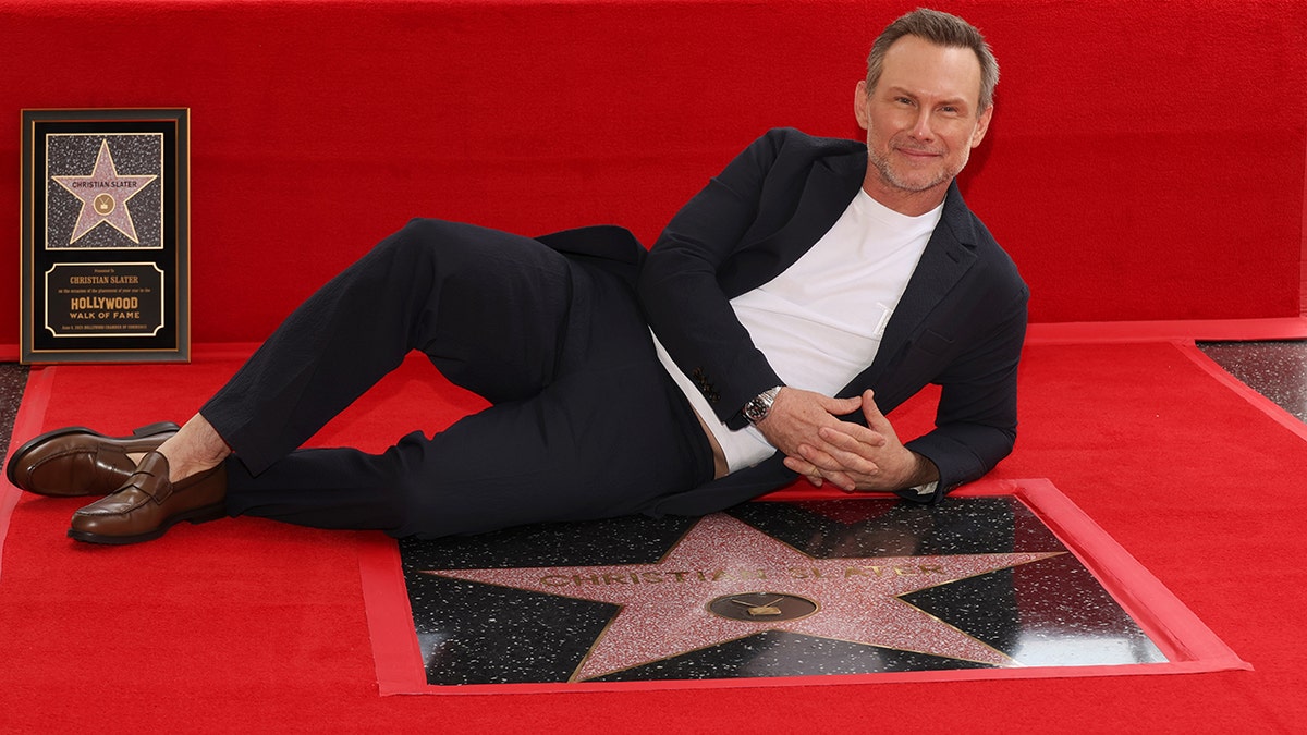 Christian Slater lies beside his star