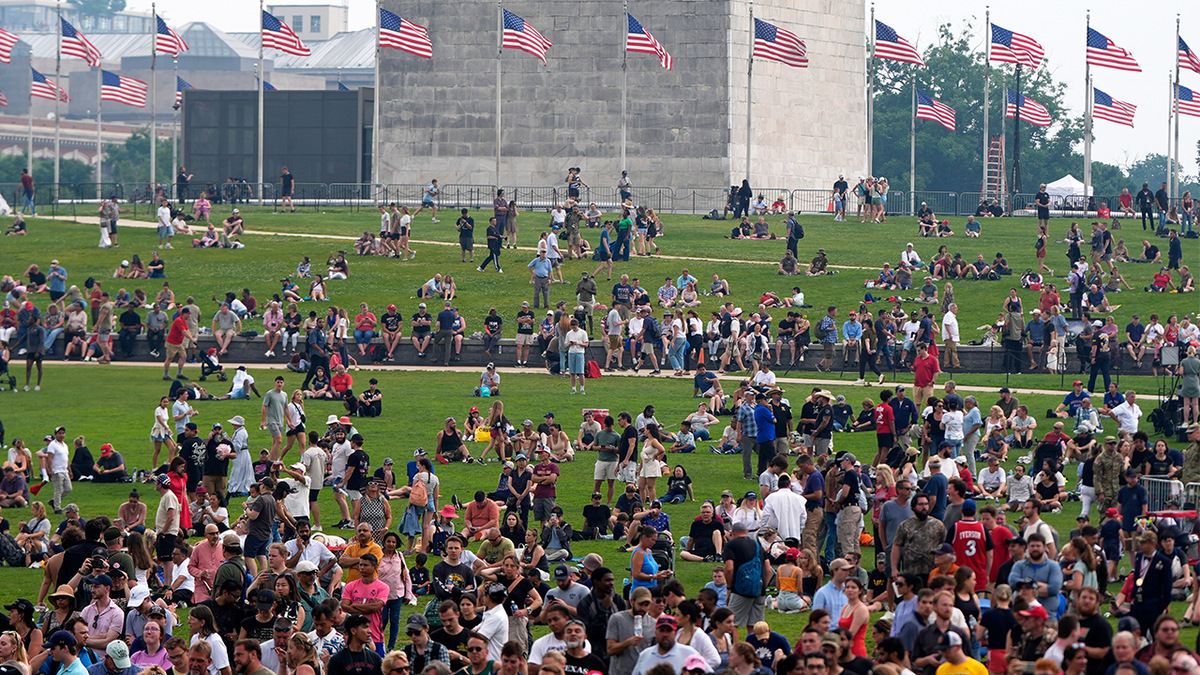 O povo do gramado em torno do memorial de Washington, como presidente Donald Trump, participou de uma marcha militar em memória do 250º aniversário do Exército em Washington no sábado, 14 de junho de 2025.