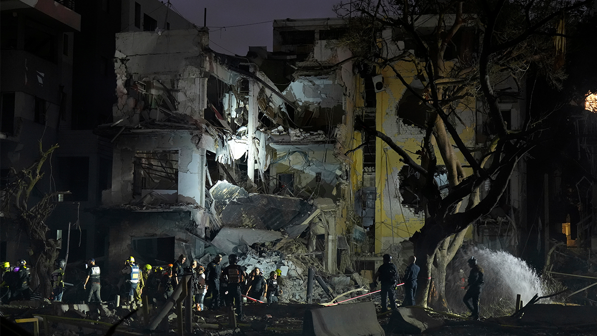 Rescue team work at the site where a missile launched from Iran struck Tel Aviv