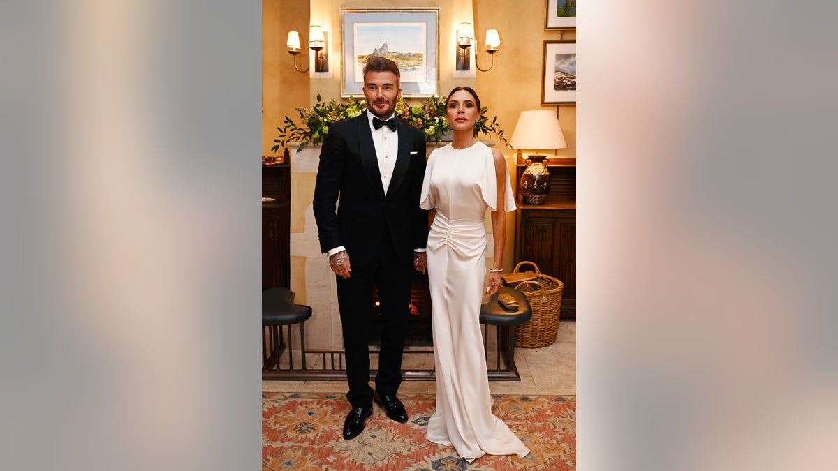 David and Victoria Beckham posing in formal wear inside a palatial home.