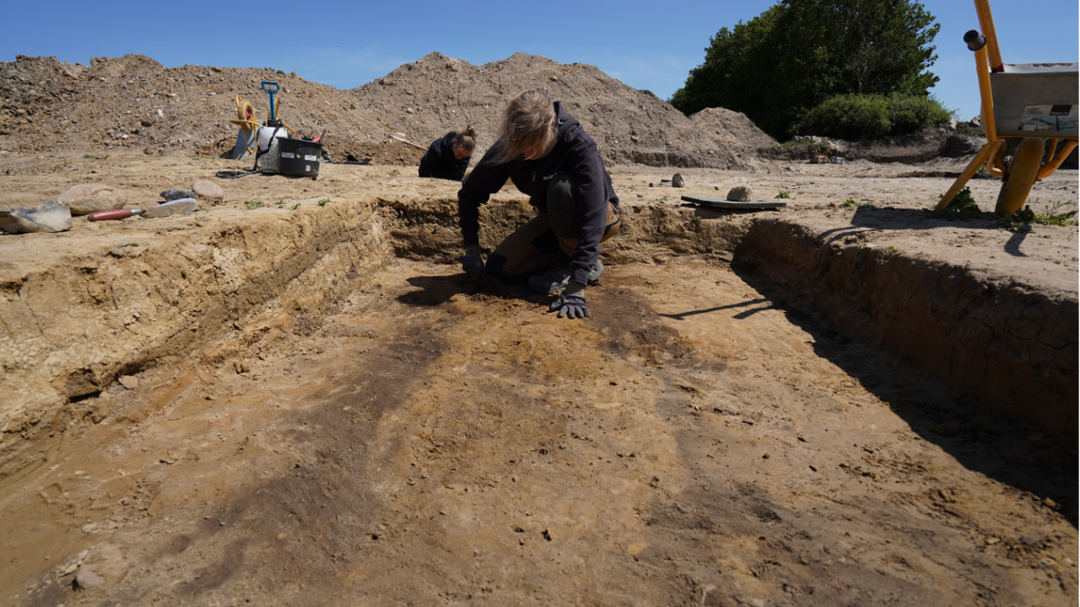 Archaeologist digging through dirt at site