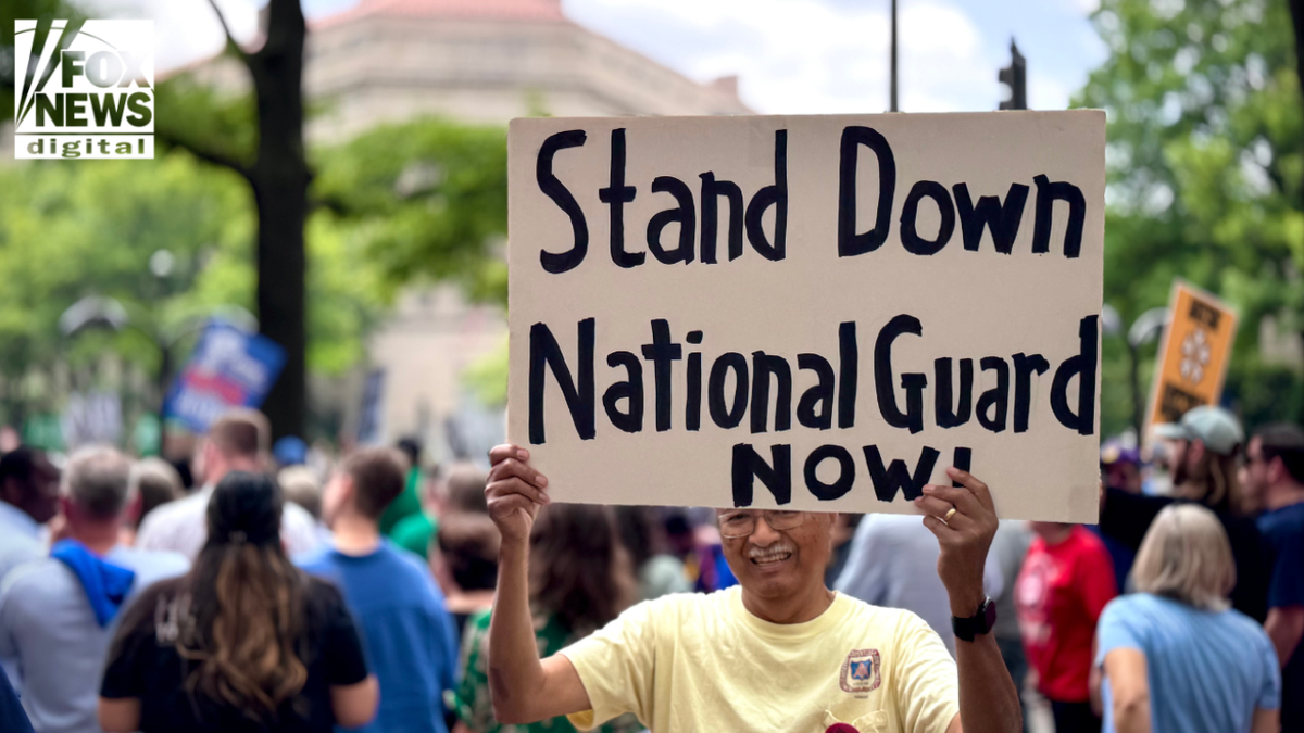 A protester successful  a yellowish  garment  holds a ample  motion   speechmaking  