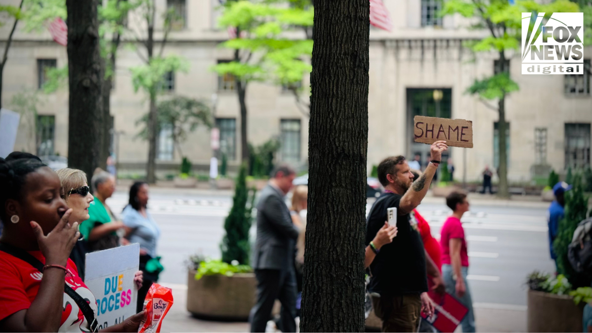 A protester raises a cardboard motion   speechmaking  