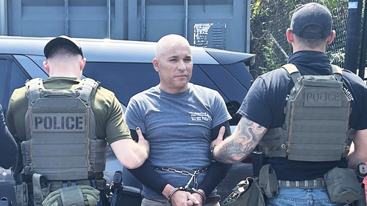 Emelio Neftaly Pineda handcuffed and being escorted by two ICE agents