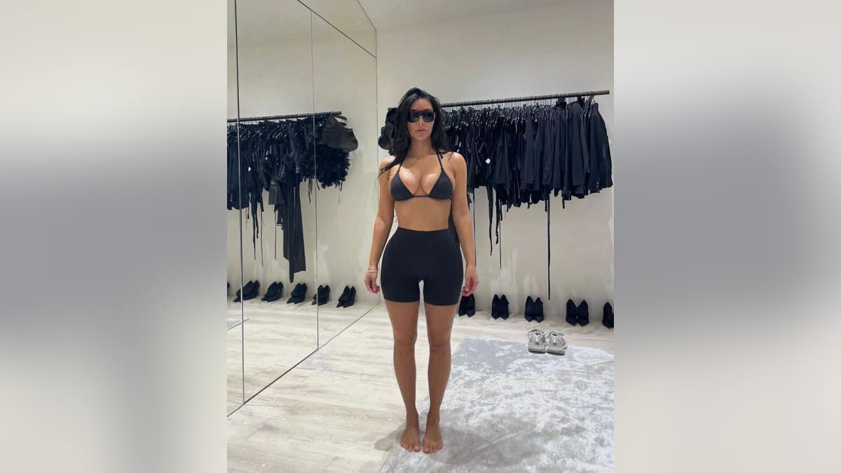 kim kardashian in black bikini top and black shorts shapewear