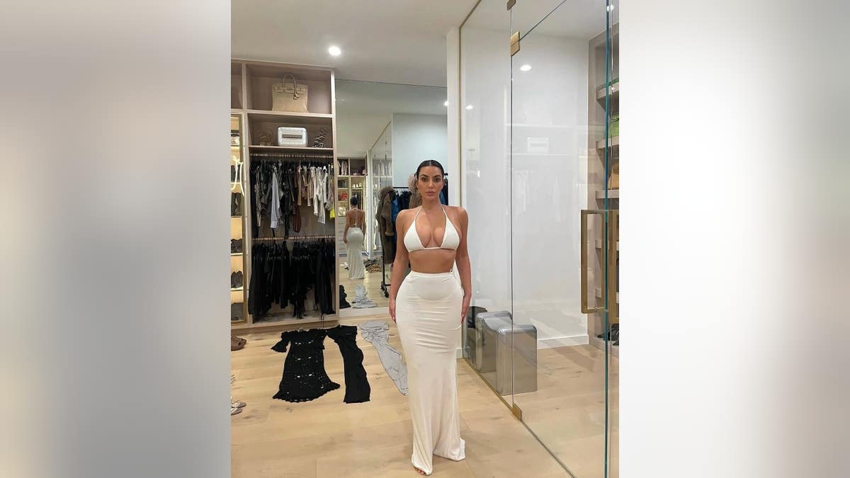 kim kardashian modeling a white bikini top and white semi-sheer skirt