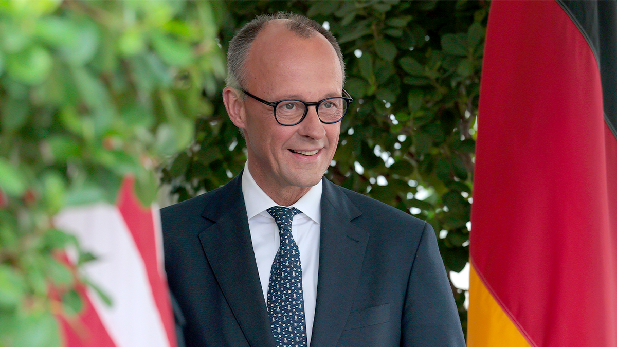 Friedrich Merz between American and German flags.