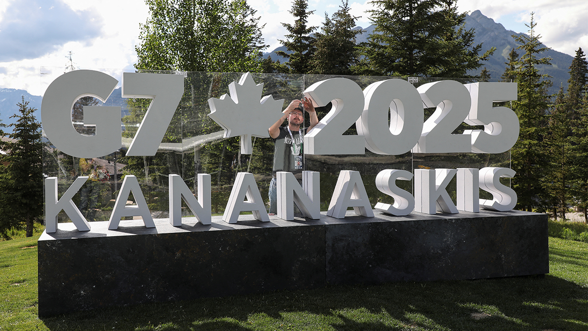 Workers prepare signs before G7 summit
