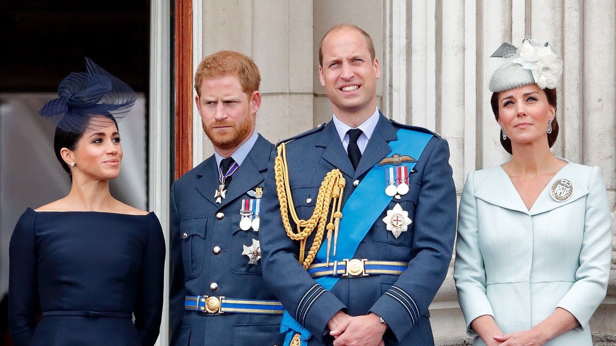 Meghan Markle, Prince Harry, Prince William and Kate Middleton standing together in formal wear on the balcony of Buckingham Palace.