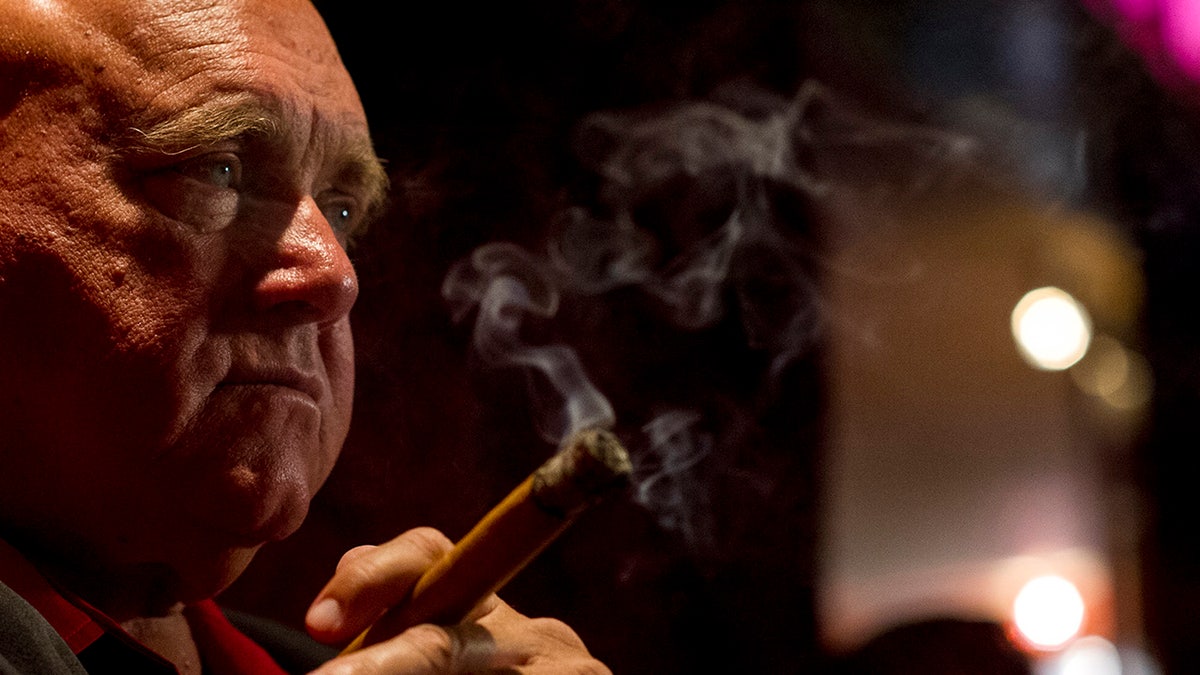 Side profile of Dennis Hoff smoking a cigar.