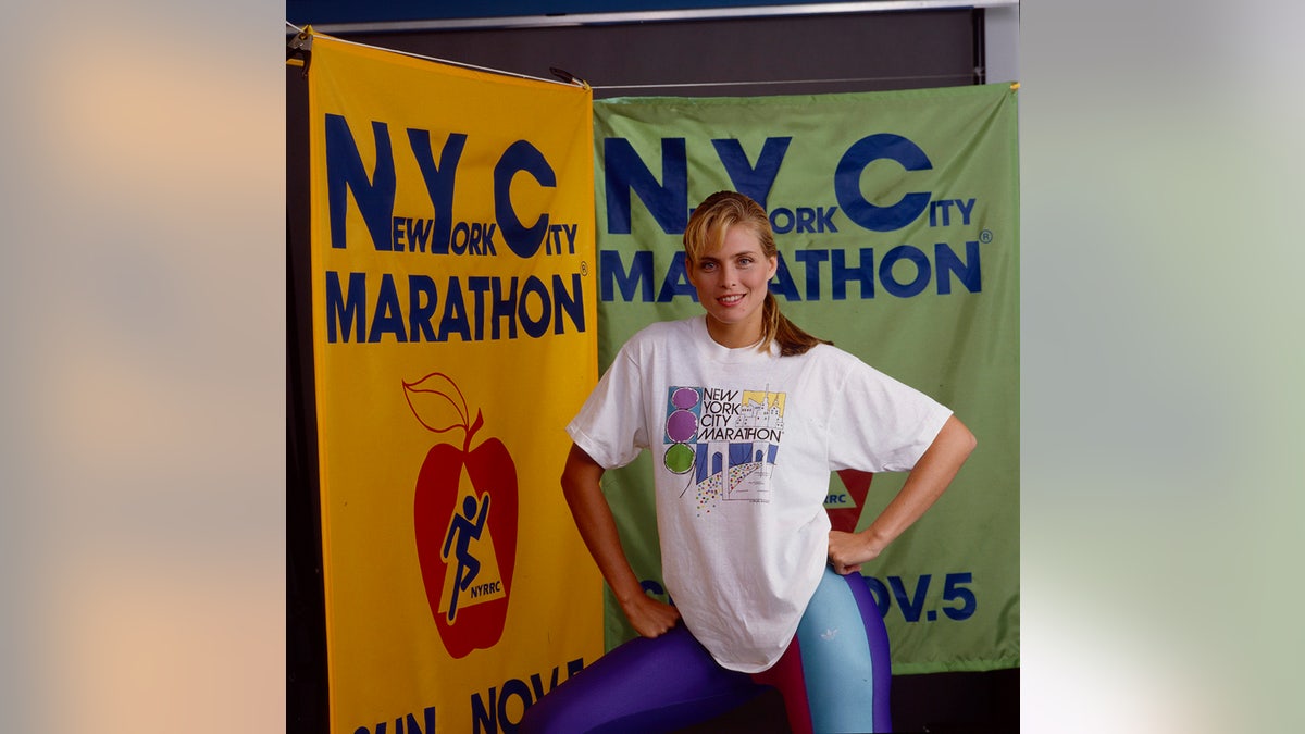 Kim Alexis posing in blue spandex and a white shirt.