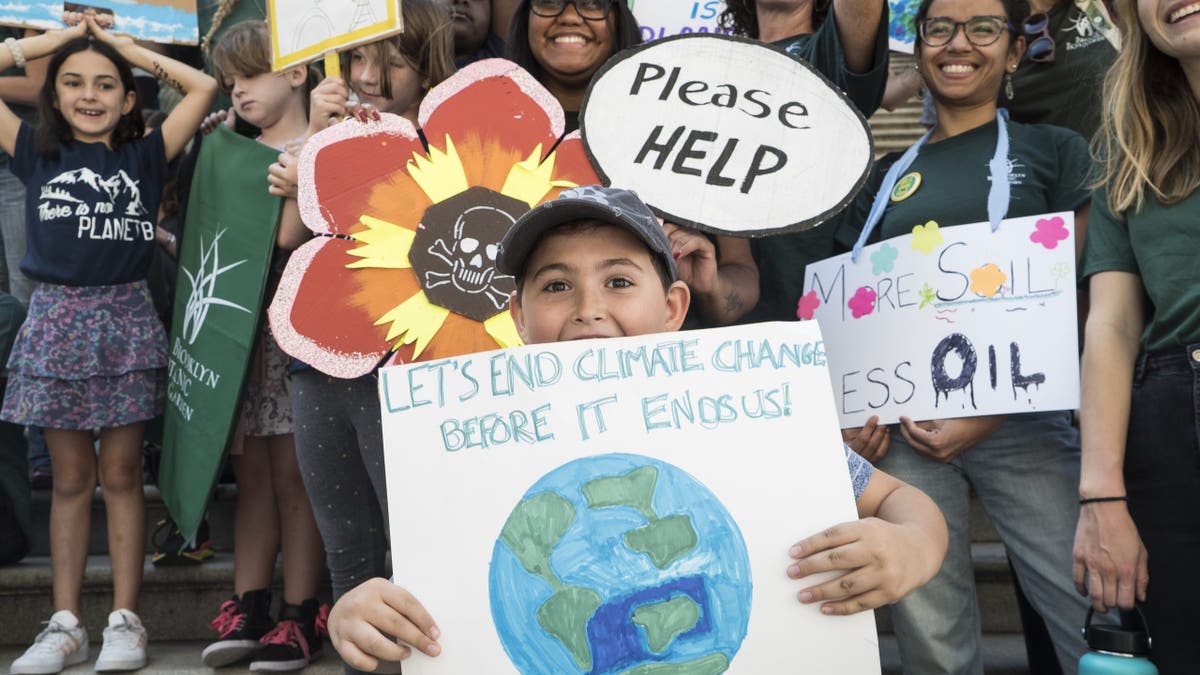 Kids at climate protest with signs