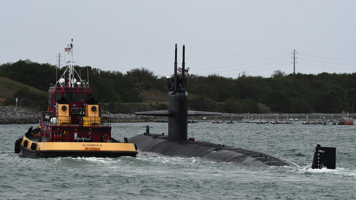  A tugboat escorts a nuclear powered U.S. Navy Virginia-class fast attack submarine into Port Canaveral ahead of the attempted launch of the Relativity Space Terran 1 rocket from pad 16 at Cape Canaveral Space Force Station