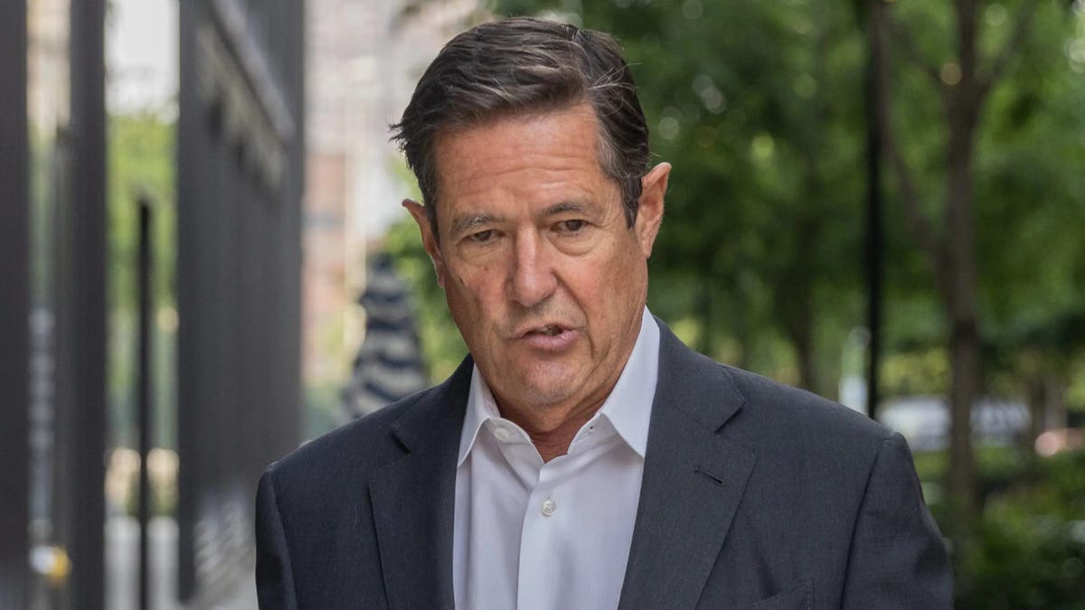 Jes Staley walks on a city block, wearing a suit and no tie