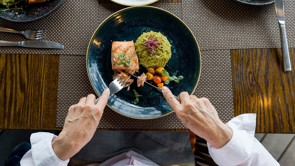 woman eating salmon for dinner 