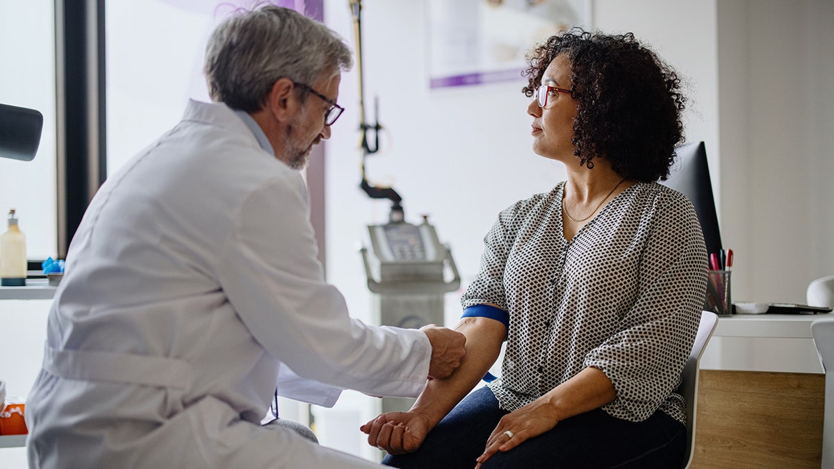 woman having blood drawn by doctor