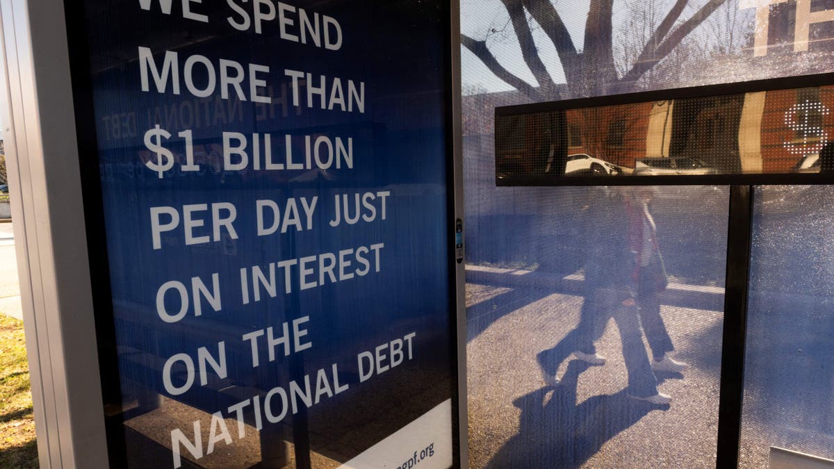 sign about the national debt in bus shelter